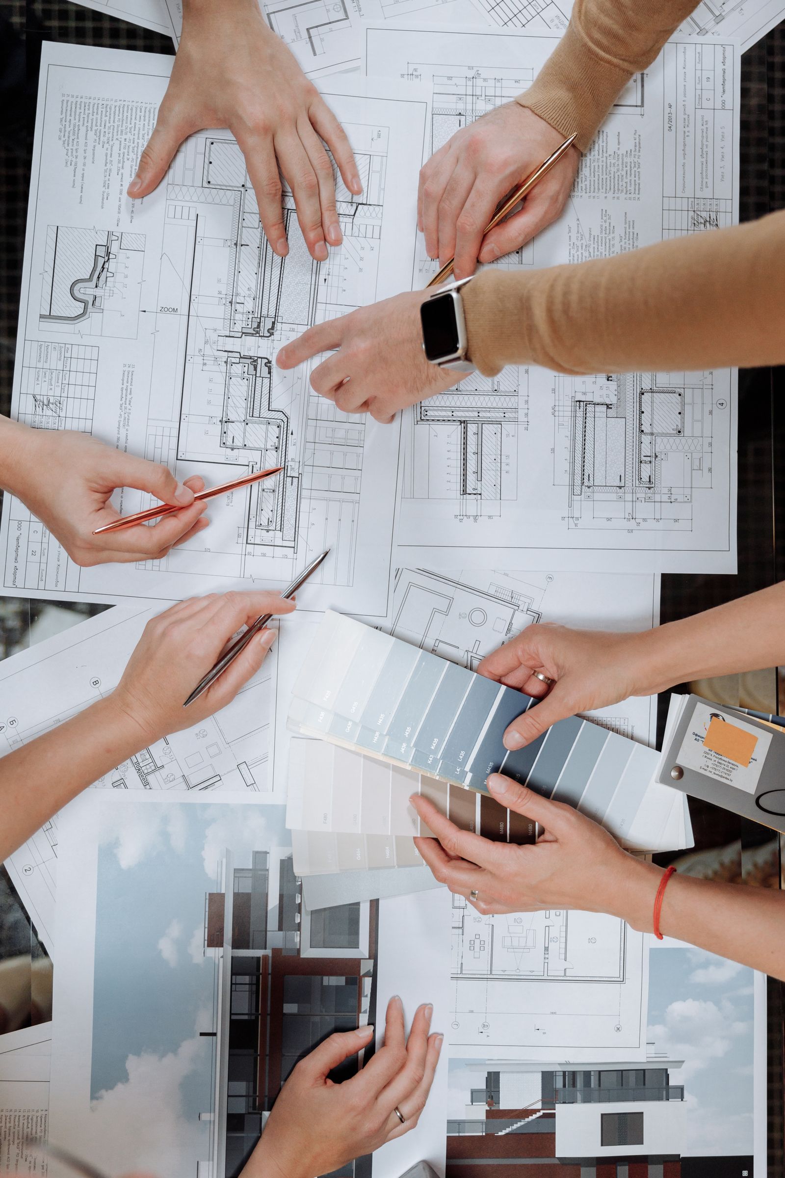 Mains posées sur des plans de construction autour d'une table