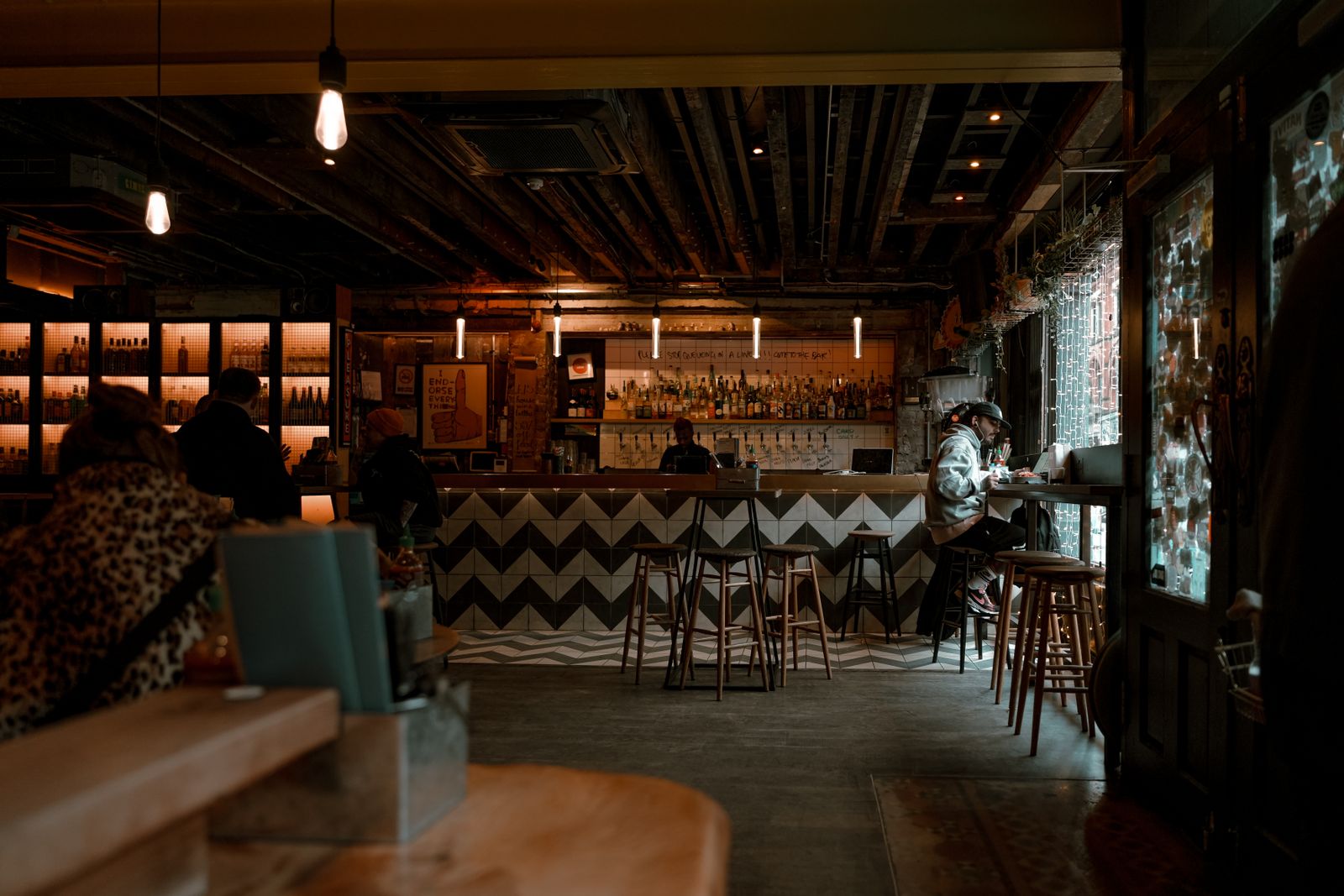 Salle et comptoir d'un bar brasserie le soir