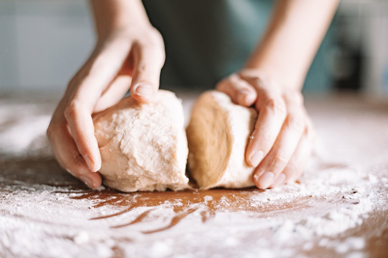 Mains du boulanger façonnant deux pâtons dans la farine