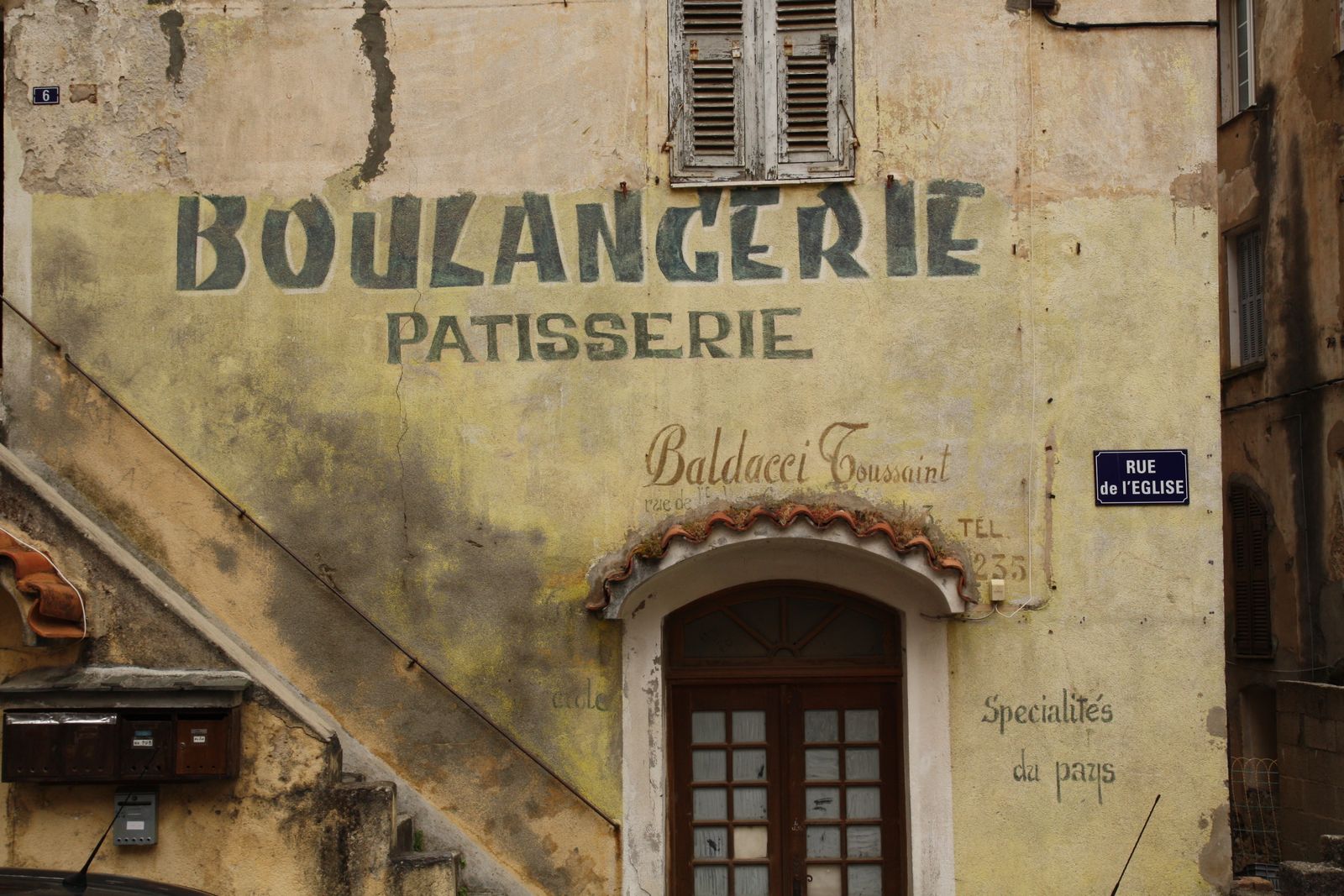 La façade ancienne de la boulangerie, son enseigne peinte sur le mur