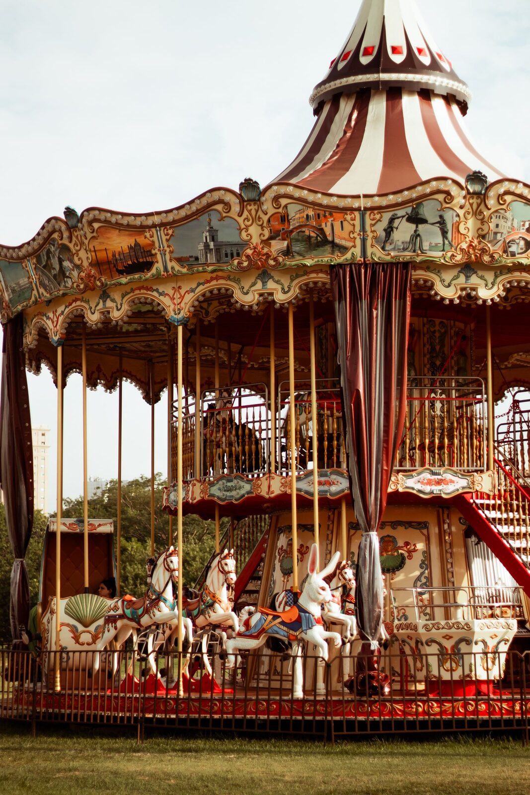 Le manège de chevaux de bois dressé pour la foire, toile rouge et blanche
