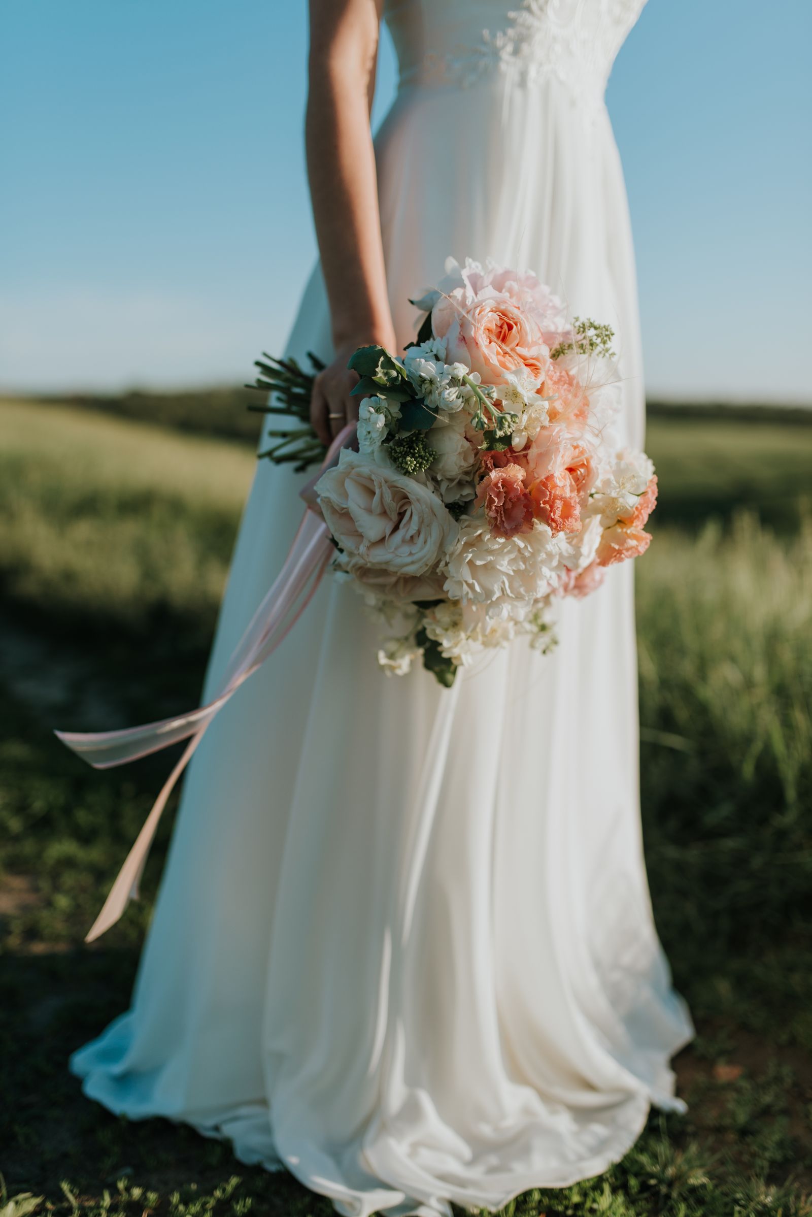 Mariée au bouquet photographiée dans un champ